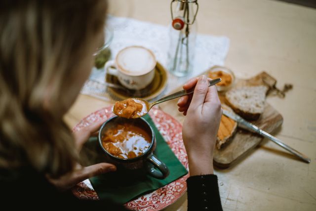 Vrouw eet soep met brood in een restaurant