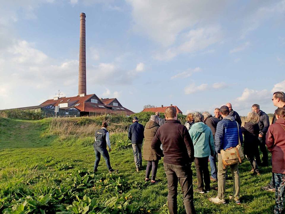 Passagiers hebben het schip verlaten en gaan met de gids op wandelexcursie door de Polder