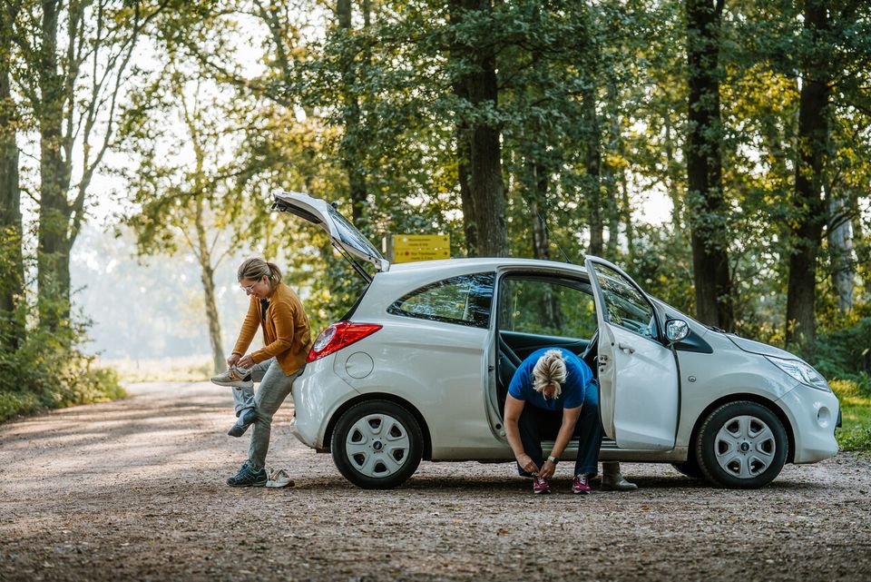 Twee figuranten in de auto veters strikken