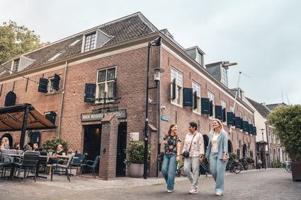 Stadshotel en restaurant Van Rossum in Woerden, Groene Hart, historisch pand met terras waar drie vrouwen door de binnenstad wandelen.