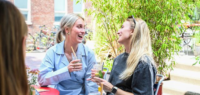 Twee meiden die een drankje doen op het Doelenplein in Delft