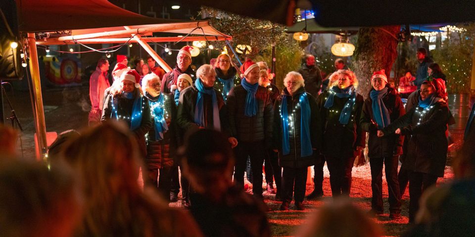 Een kerstkoor zingend door de straten van de binnenstad van Delft