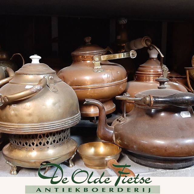 Oude koperen theekannen in de boerderijschuur van De Olde Fietse.