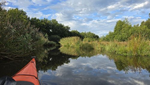Uitzicht vanuit een kajak op een bocht in de Ruiten Aa, met groene oevers en weerspiegeling in het water. Eigen routebeeld uit september 2026.