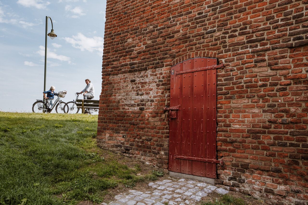 Detailfoto Gevangentoren Megen met fietsers op de achtergrond