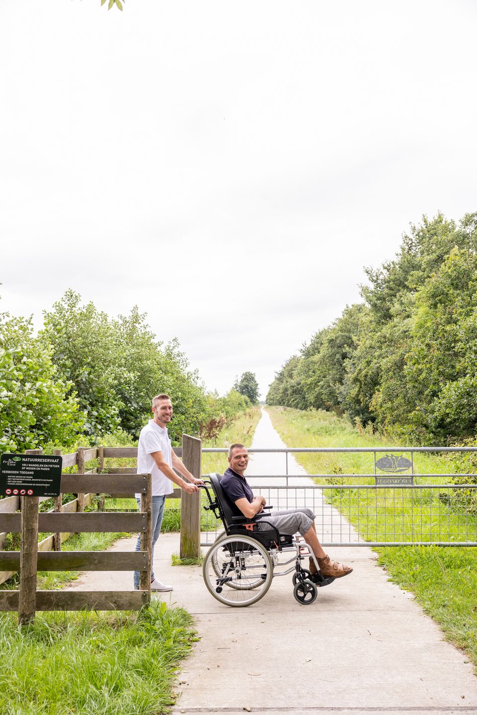 Mensen met rolstoel wandelen over een pad.