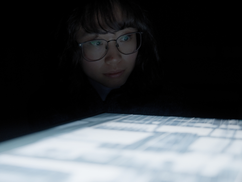 Vrouw die verbaast, kijkt naar een scherm tijdens Highlight Delft, een lichtfestival in Delft