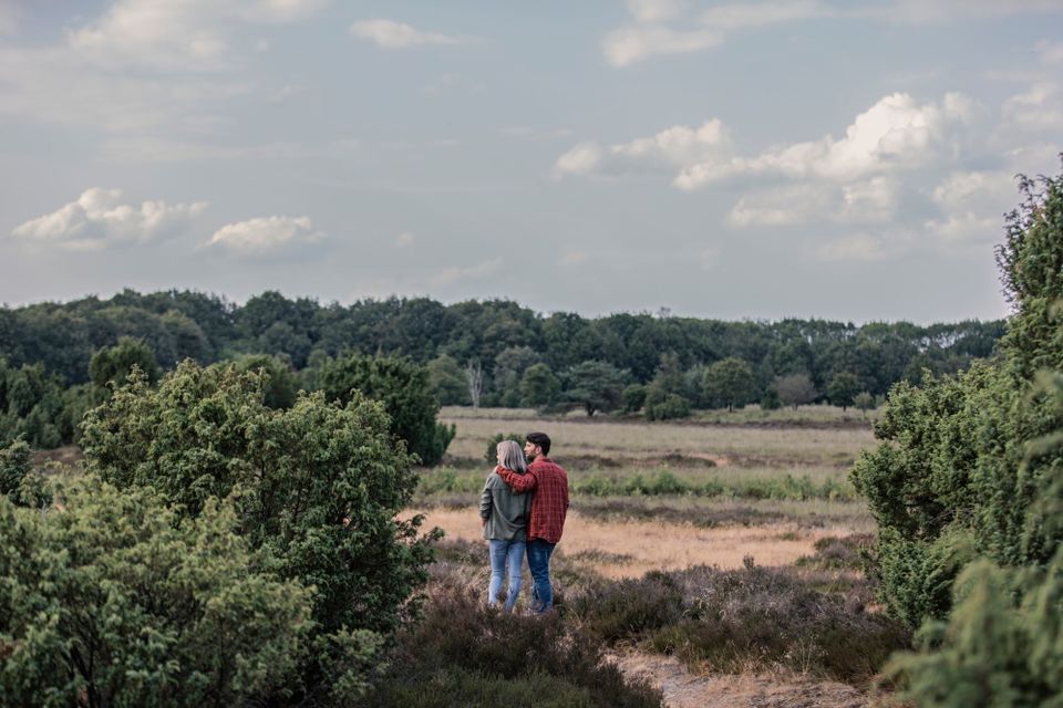 Een stel wandelt door door de Drentse natuur en geniet van het uitzicht.
