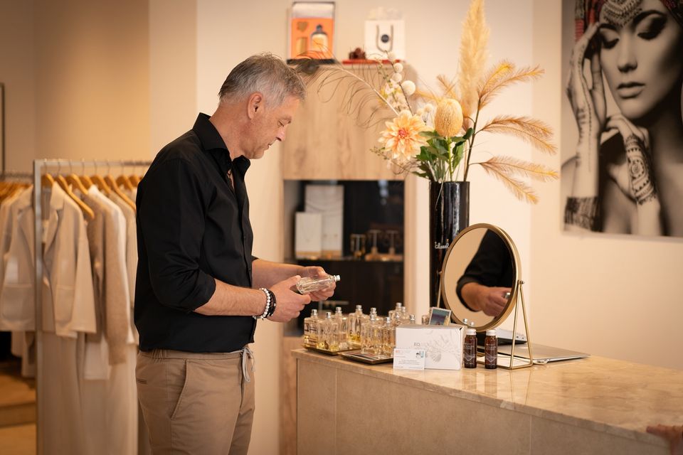 Een man die bij de parfums staat van Hermée