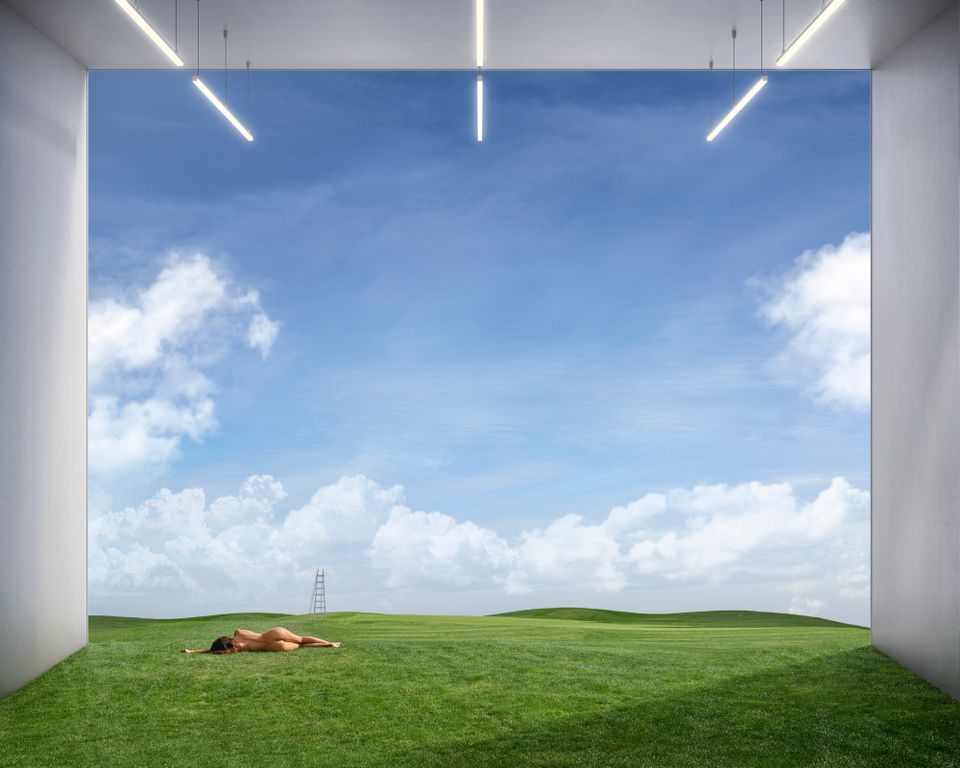 Naakte vrouw ligt op haar zij in landschap