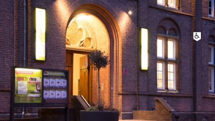 Het Klooster in Woerden, historisch gebouw met verlichte entree in de avond, gelegen in het centrum van de stad.