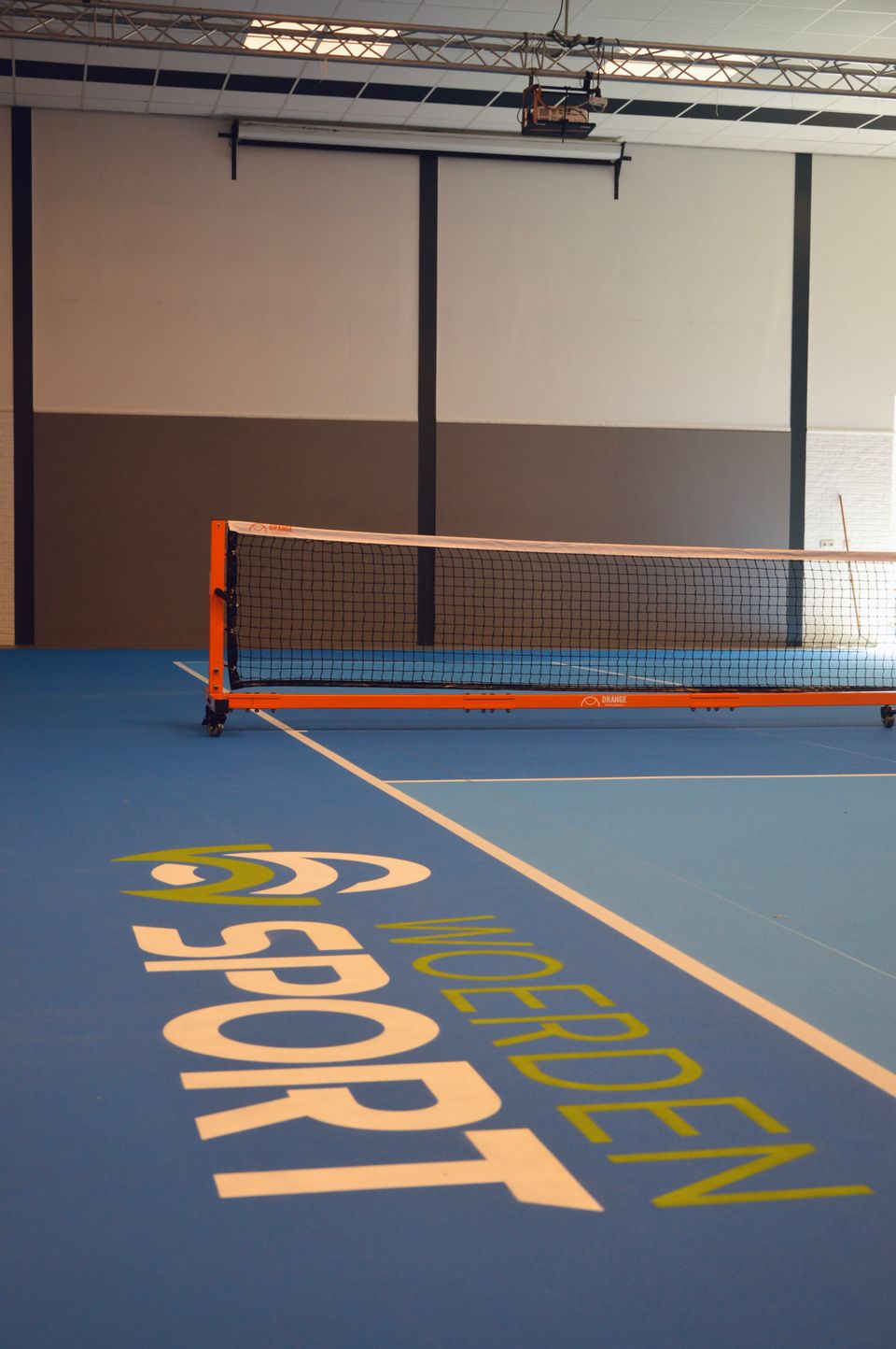 Pickleballbaan bij Zwembad H2O in Harmelen, Groene Hart, met blauw speelveld, witte belijning en pickleballnet in de overdekte sporthal.