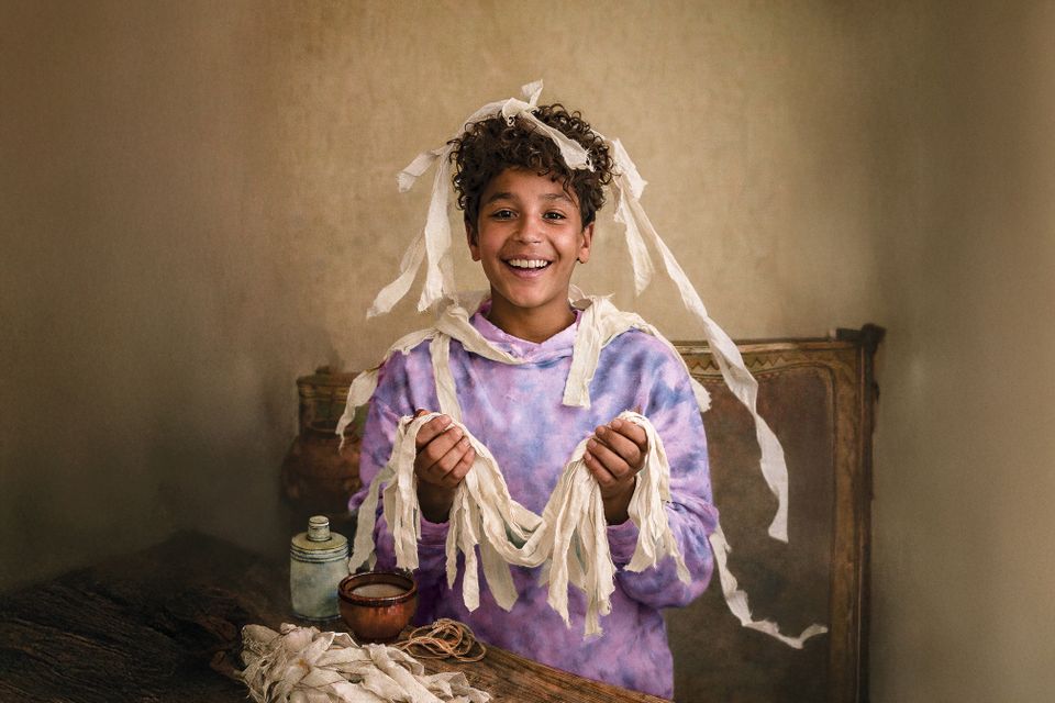 Jongen met windsels om een mummiedier te maken