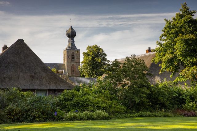 Bauernhöfe und ein Kirchturm im Brinkdorf Dwingeloo in Drenthe.