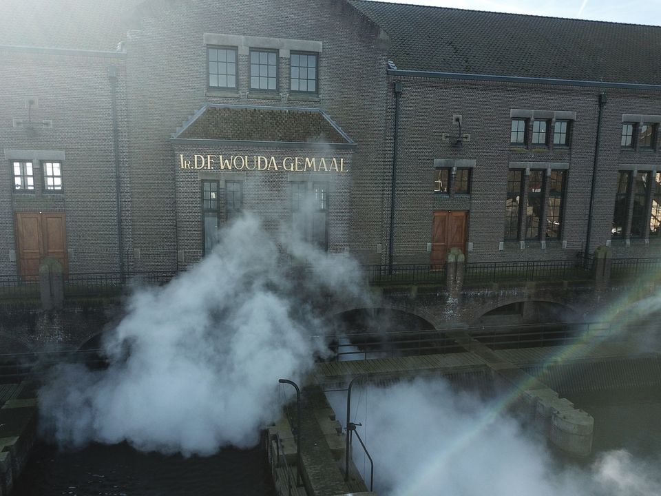 woudagemaal in gouden letters en stoom aan de voorkant van het gebouw