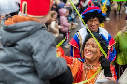 Piet geeft kind pepernoten