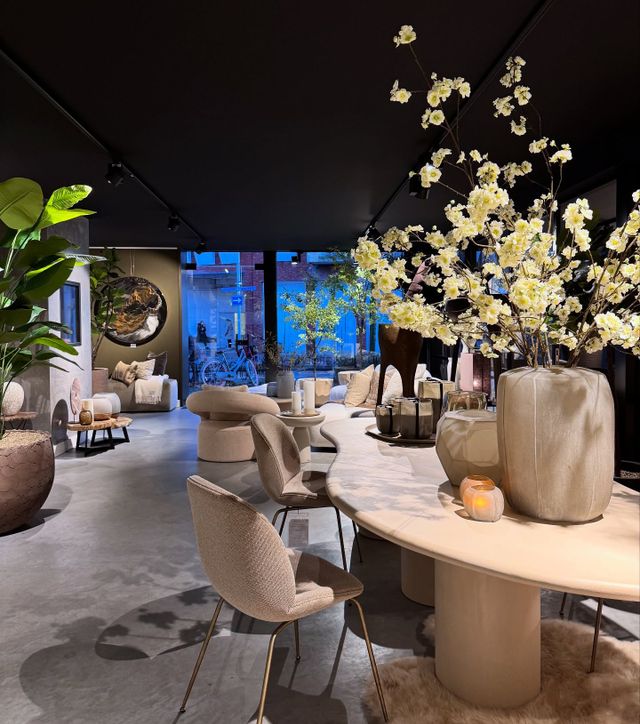 Houten tafel met stoelen, bloemen en andere accessoires bij winkel Nu Puur & Groen in Oisterwijk