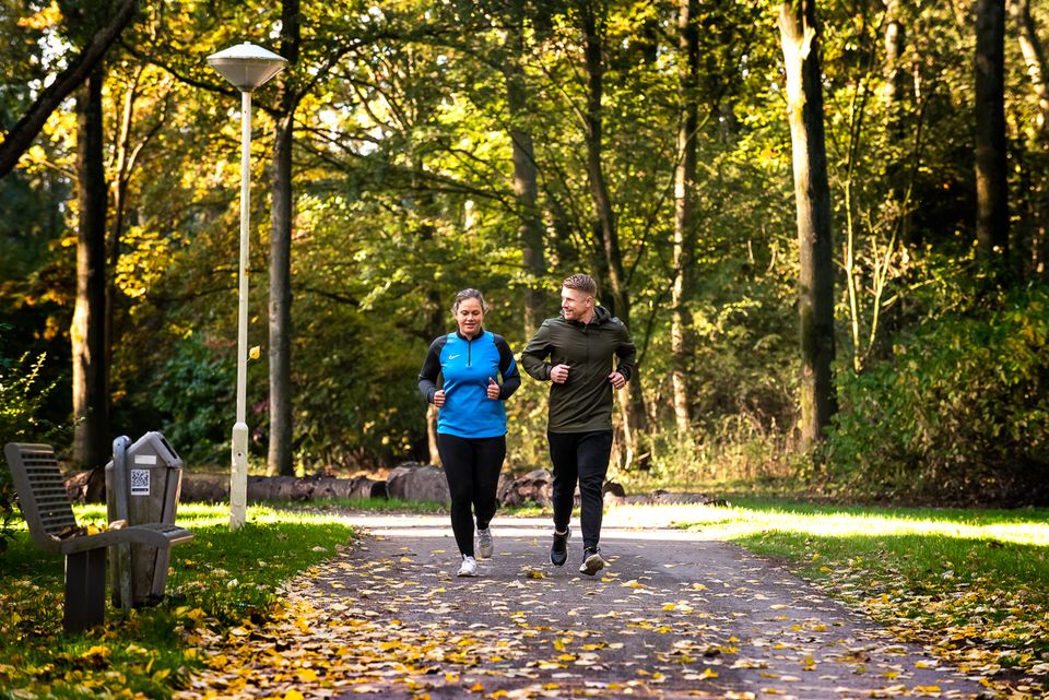 Een man en vrouw zijn samen aan het hardlopen in het van Tuyllpark.