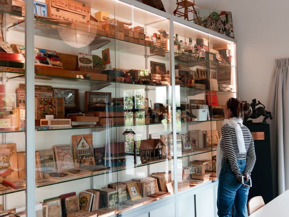Een vrouw die naar de boeken kijkt van Dik Trom in het Schooltje van Dik Trom in Etersheim