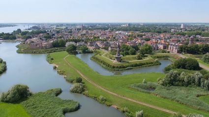 Luchtfoto van vestingstad Gorinchem met zicht op Molen De Hoop, de Dalempoort en de omringende wateren en stadswallen in het Groene Hart.