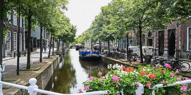 Kijkje op de grachten in Delft met een gezellige terrasboot in de zomer