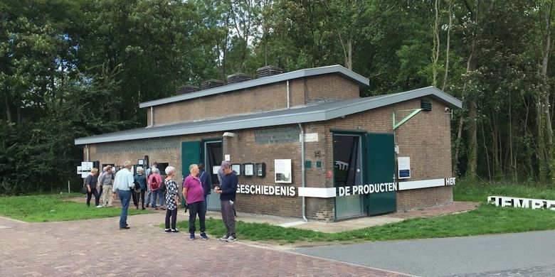 Een groep mensen kijkt rond bij een museum dat in een oud transformatorhuisje gemaakt is.