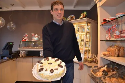 Winkel van de bakkerij Van Hulten met op de voorgrond de bakker met een slagroomtaart.