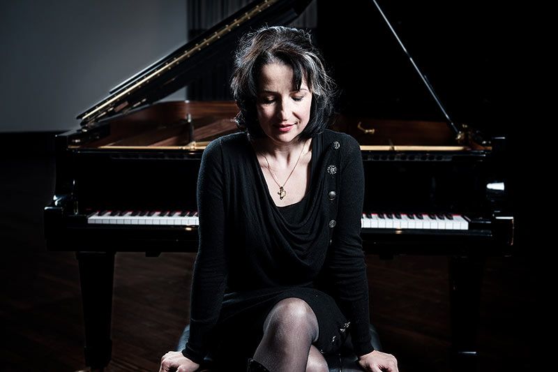 Vrouw zittend voor een piano