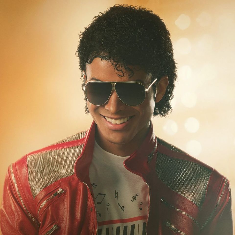 Foto van een jonge Michael Jackson met een zonnebril op en met een rood leren jasje met blinkertjes aan.