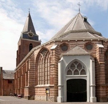 Historische Petruskerk in Woerden, Groene Hart, monumentale bakstenen kerk met kerktoren, spitsboogvensters en karakteristieke entree.