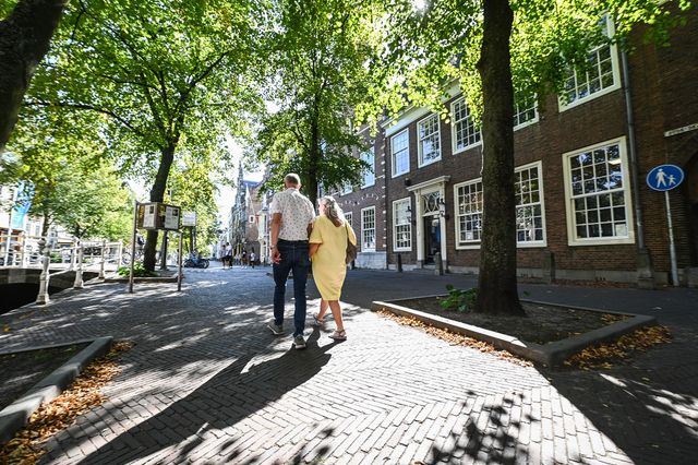 Koppel wandelt over de Oude Delft naar een Vermeer kubus