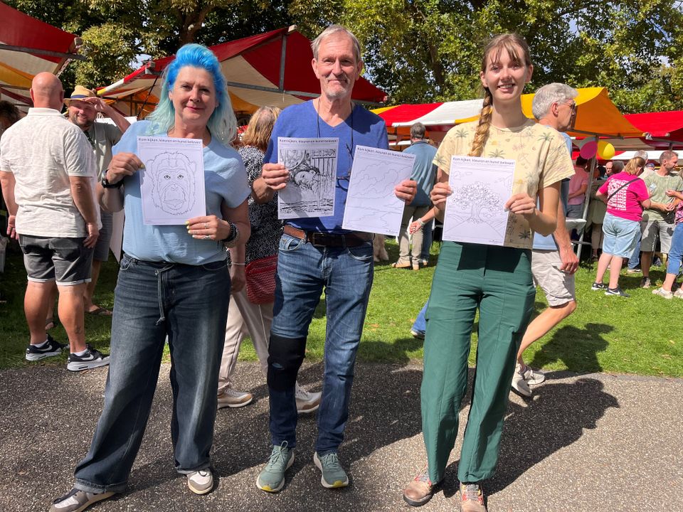 Bezoekers tonen kleurplaten tijdens de kleurplaatactie bij de heropening van De Stadskamer in Woerden.