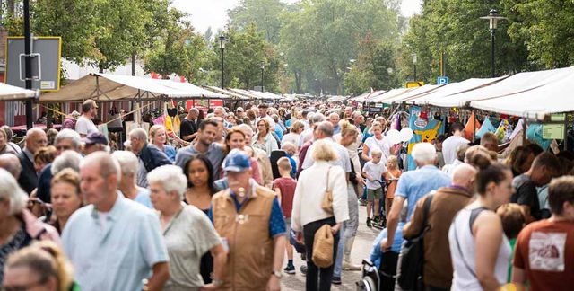 Menigte aan mensen die struinen over de Septembermarkt in Harmelen met bomen op de achtergrond.