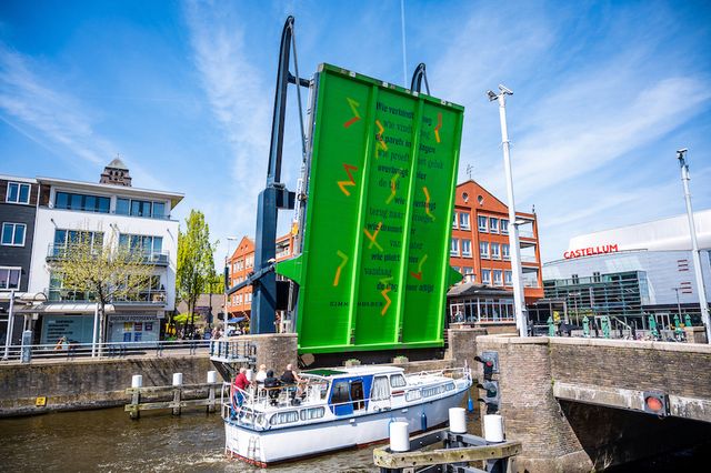 De Alphense brug die open staat met waardoor er een gedicht is te zien op de onderkant van de brug.