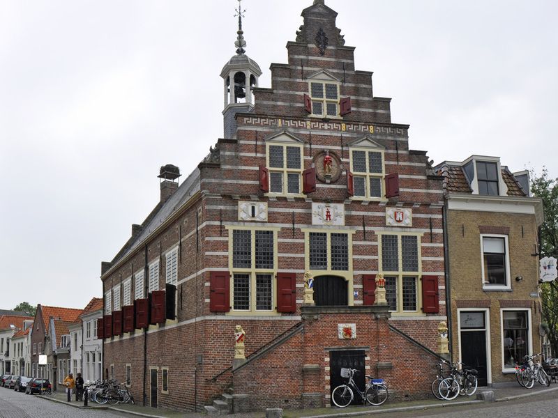 Historisch stadhuis van Oudewater met karakteristieke trapgevel, rood-witte luiken en bakstenen gevel, gelegen in het oude centrum van Oudewater.