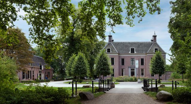 Brug die leidt naar Landhuis Oud Amelisweerd, omringd door groene bomen