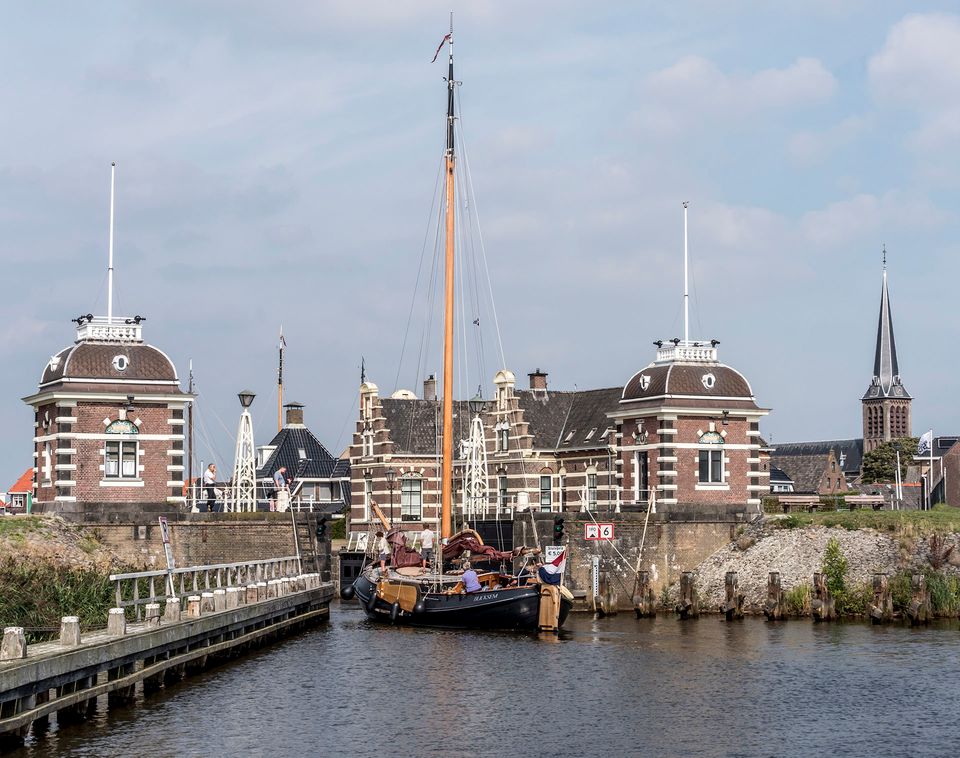 Een zeilboot die uit een sluis komt in Lemmer
