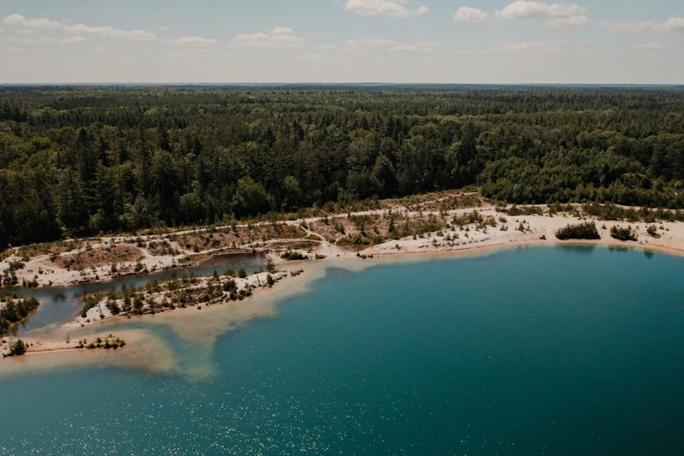 Luftaufnahme eines Badesees in der Natur in Drenthe mit klarem, blauem Wasser.