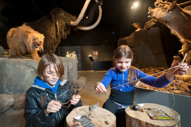 Meisje en jongen zijn bezig met touw, ervaren hoe er vroeger dingen werden gemaakt.