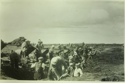 Arbeiders bezig met de aanleg van een van de startbanen van vliegveld Peest, met behulp van kiepkarren.