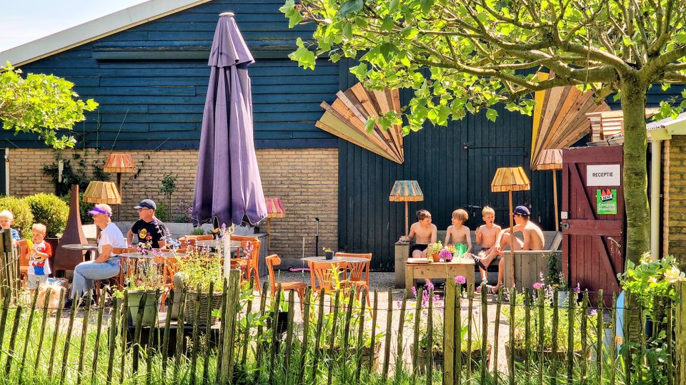 Receptie en terras aan speeltuin van de camping