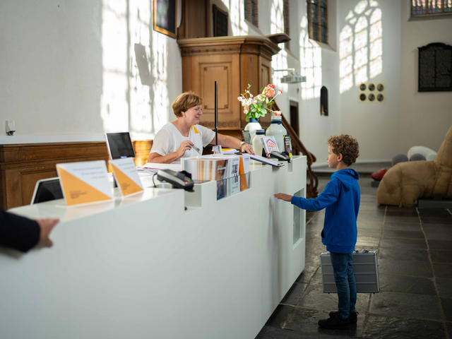 Kind bij de kassa van het Museum Prinsenhof Delft