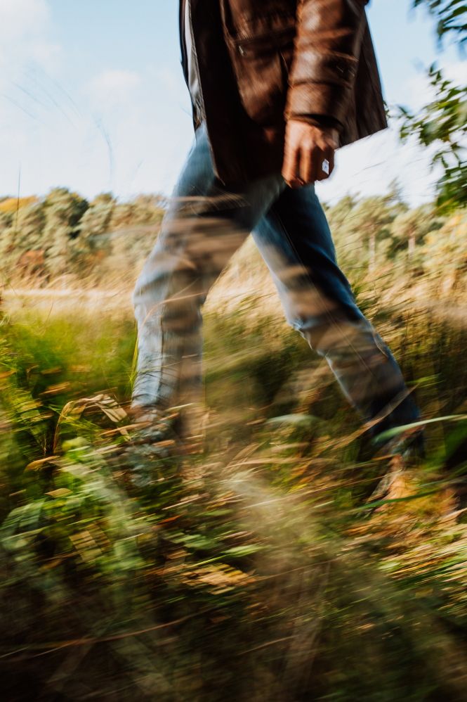 De benen van een wandelende man in de Drentse natuur.