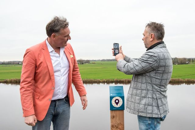 Belevingswandelroute van Muiden - Gooise Meren. Twee mannen wandelen de belevingsroute met behulp van de mobiele app.