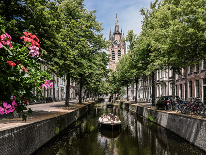 Zomerse dag in Delft met een bootje op de grachten en uitzicht op de Oude Kerk