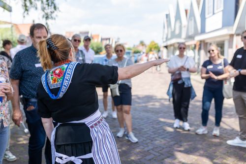 Een Volendamse gids die mensen rondleidt