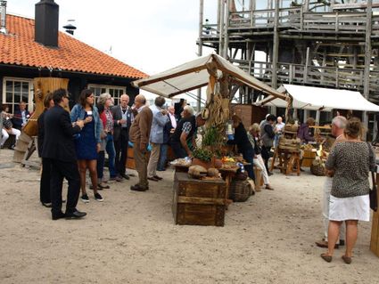 Groep mensen bij kraampjes.
