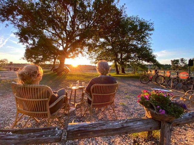 Terras 't Bluk aan de heide in Laren. Bezoekers genieten van  het uitzicht en de ondergaande zon op het terras.