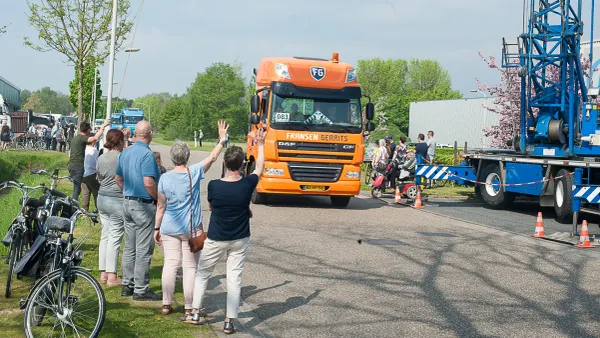mensen zwaaien naar passerende trucks