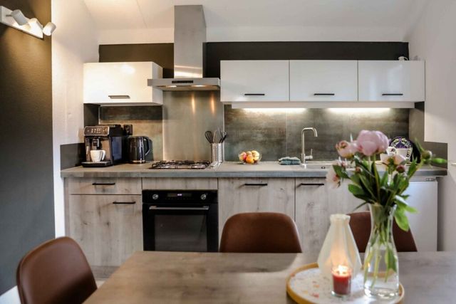 Compleet ingerichte keuken en gezellige eethoek met combi-oven, kookplaat en koffiezetapparaat.